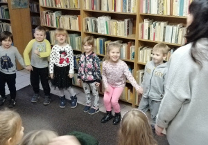Dzieci bawią się w kole z panią bibliotekarką